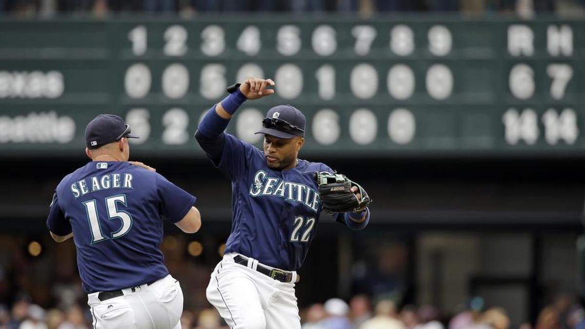 Kyle Seager (15) and Robinson Cano celebrate after Seattle defeated the Texas Rangers 14-6 at home on Monday. The Mariners remained five games back in the wild-card race.