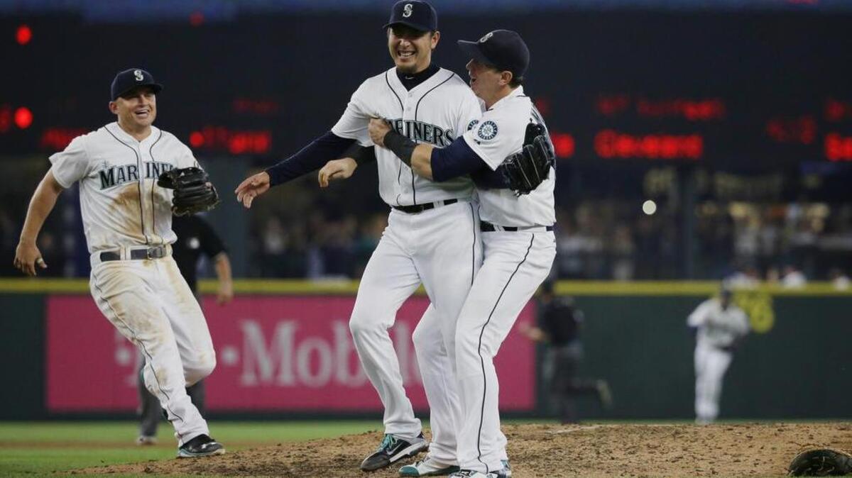 
Seattle Mariners starting pitcher Hisashi Iwakuma second from right, celebrates with third baseman Kyle Seager, left, and first baseman Logan Morrison, right, after Iwakuma threw a no-hitter baseball game against the Baltimore Orioles, Wednesday, Aug. 12, 2015, in Seattle. The Mariners beat the Orioles 3-0.
