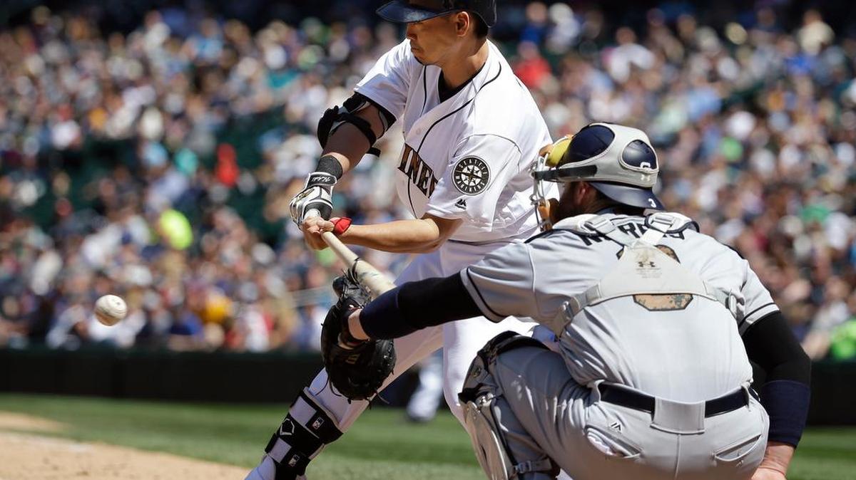 San Diego catcher Derek Norris, right, interferes on a swing by Seattle’s Nori Aoki in the sixth inning allowing Aoki a free base. The Mariners would score four runs following the call.