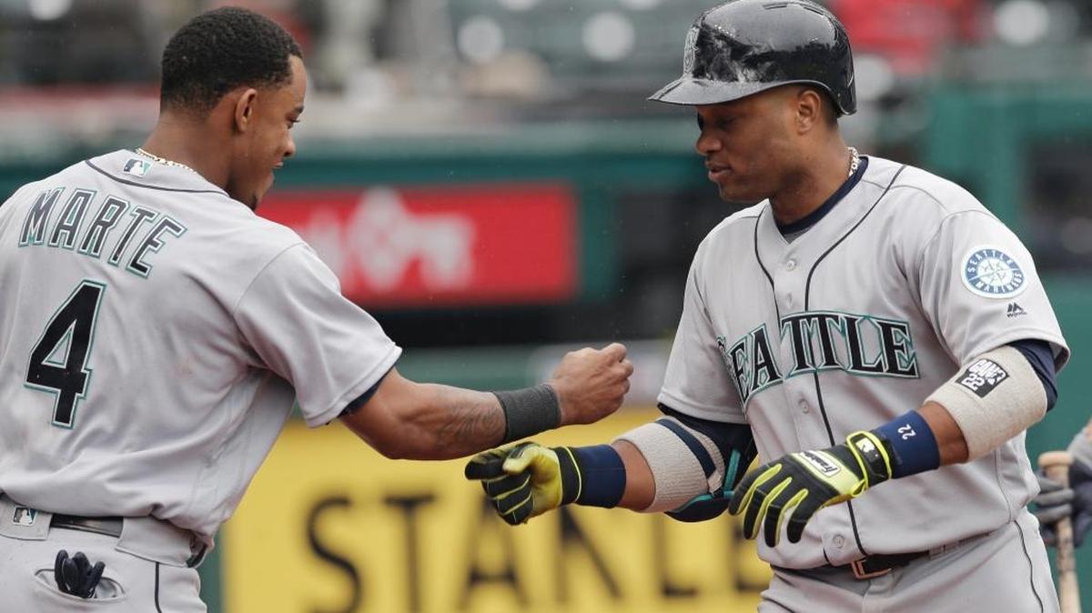 Seattle’s Robinson Cano, right, and Ketel Marte celebrate after Cano hit a three-run home run off Cleveland Indians relief pitcher Cody Allen in the 10th inning Thursday, April 21, 2016, in Cleveland. Luis Sardinas and Franklin Gutierrez scored on the play.