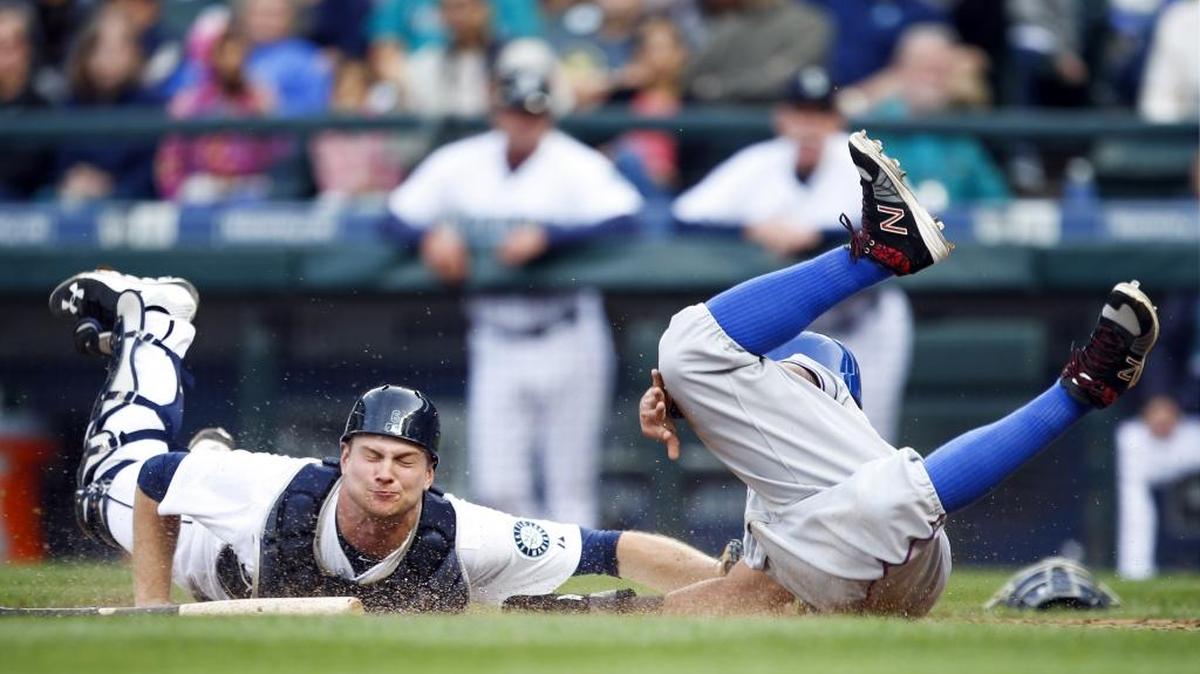 
Rangers second baseman Rougned Odor, right, beats a tag by Mariners catcher John Hicks to score a run on a wild pitch during the seventh inning.
