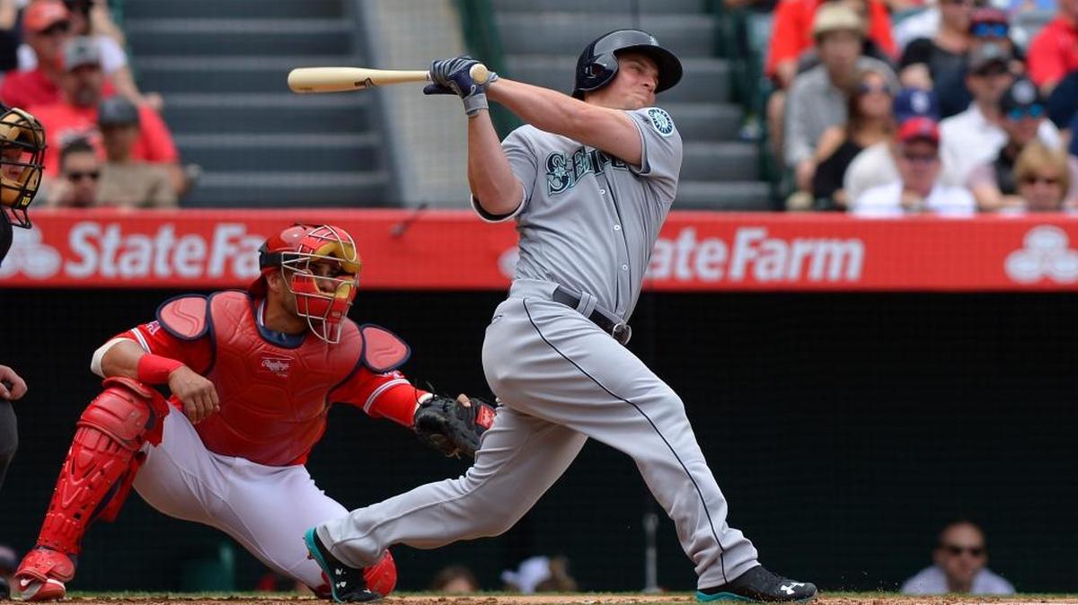 Seattle Mariners’ Kyle Seager, right, hits a three-run home run as Los Angeles Angels catcher Geovany Soto watches during the first inning of a baseball game, Sunday, April 24, 2016, in Anaheim, Calif.