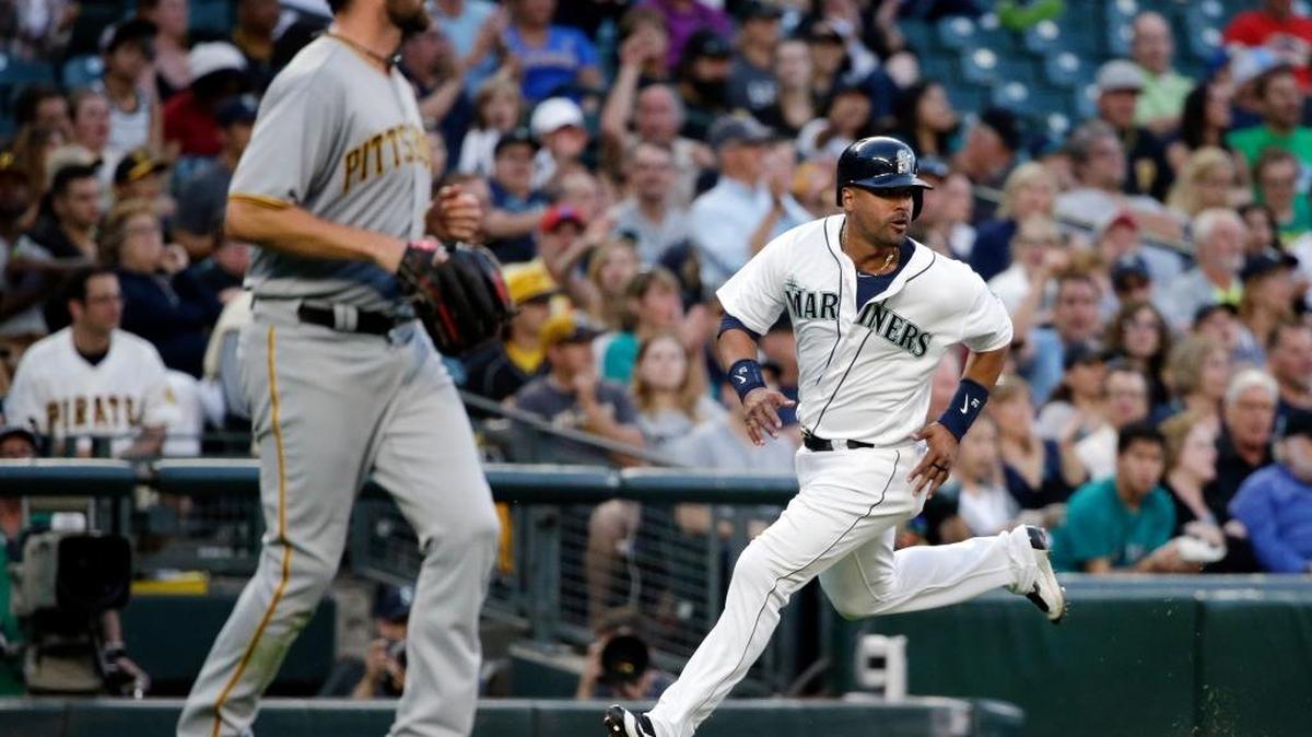 The Mariners’ Franklin Gutierrez, right, heads home to score as Pirates starter Jonathon Niese watches the play unfold during the fifth inning Tuesday in Seattle.