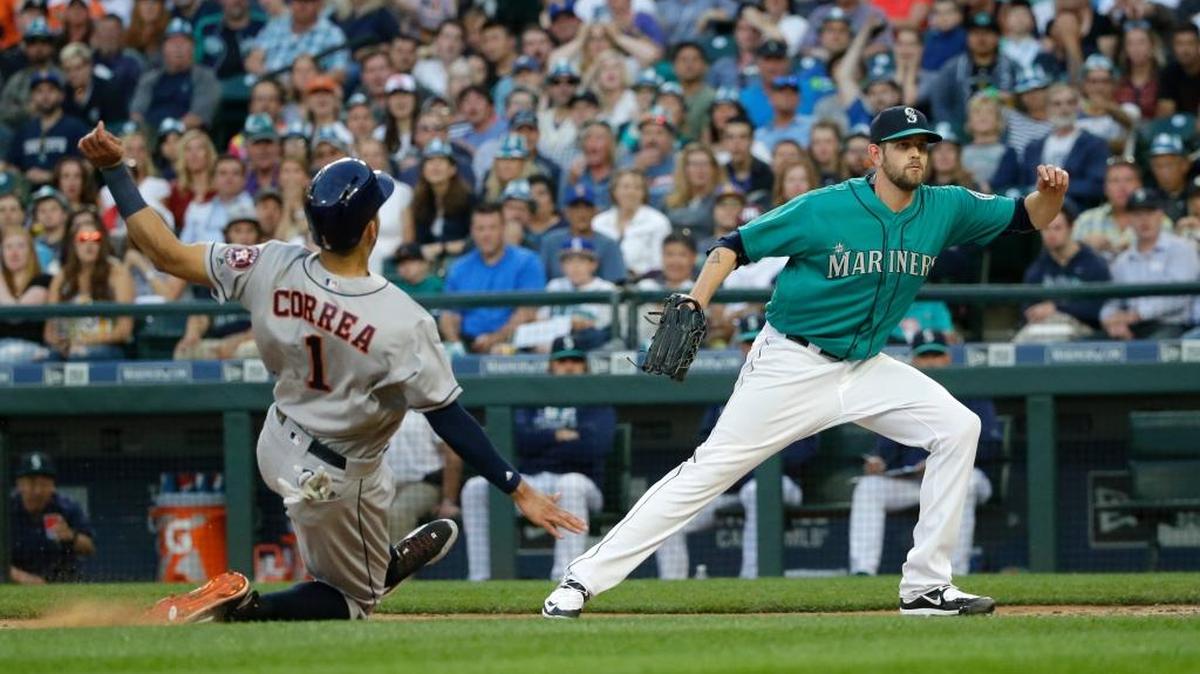 Houston Astros shortstop Carlos Correa slides into home to score on a wild pitch by Seattle Mariners starting pitcher James Paxton, right, during the fifth inning of a baseball game Friday, July 15, 2016, in Seattle.
