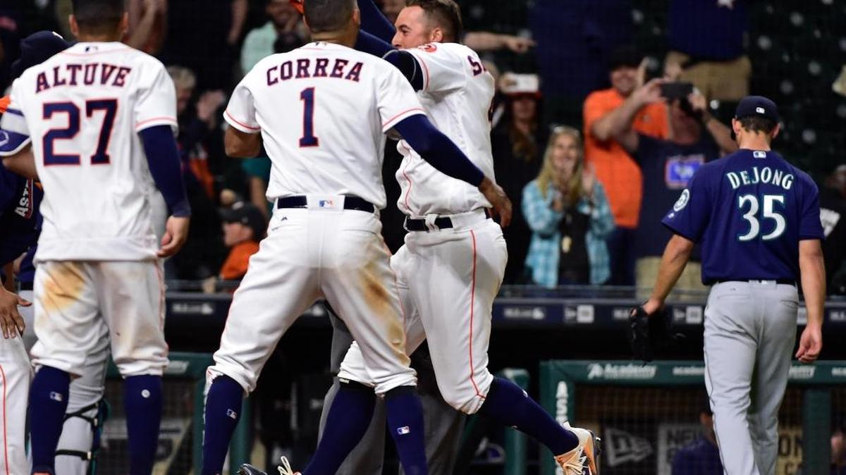 The Astros celebrate George Springer’s three-run walk-off homer as Mariners pitcher Chase De Jong walked to the dugout.