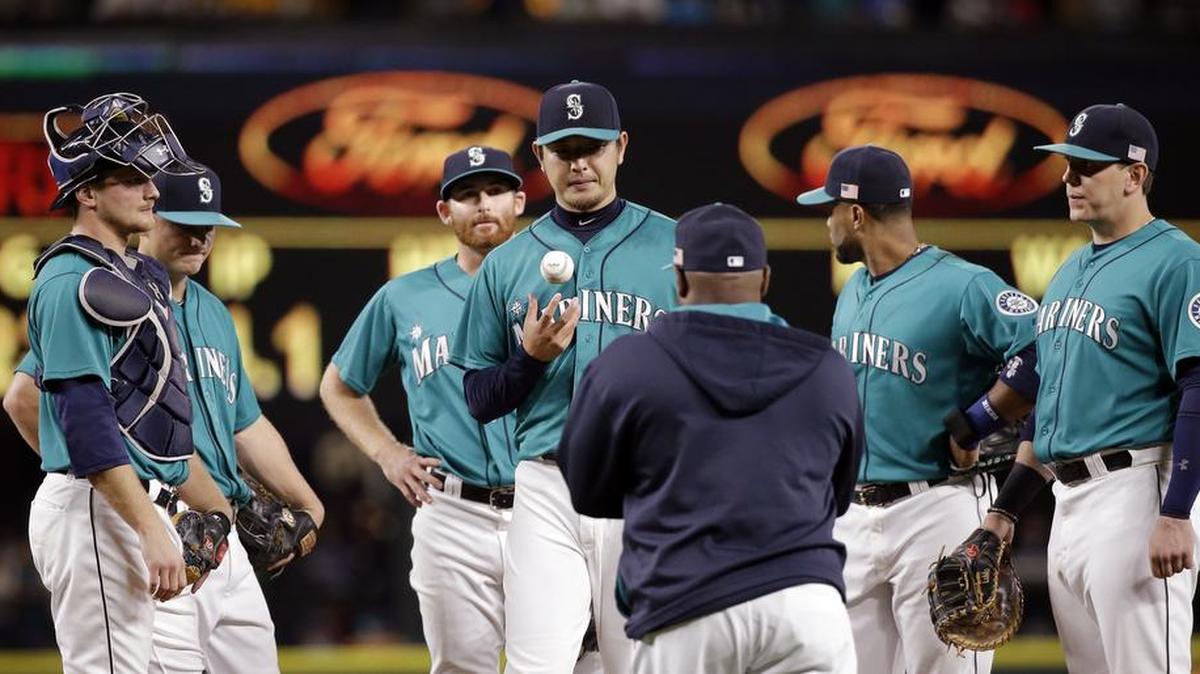 
Seattle Mariners starting pitcher Hisashi Iwakuma, center, waits with infielders to be relieved by manager Lloyd McClendon during the seventh inning against the Colorado Rockies in a baseball game Friday, Sept. 11, 2015, in Seattle.

