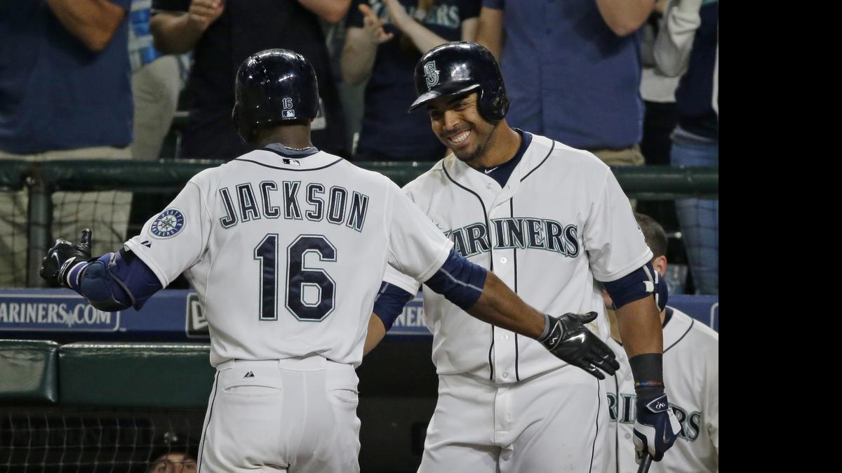 
Seattle Mariners' Austin Jackson (16) is greeted at the dugout by Nelson Cruz after Jackson hit a solo home run in the seventh inning to break a 1-all tie. 
