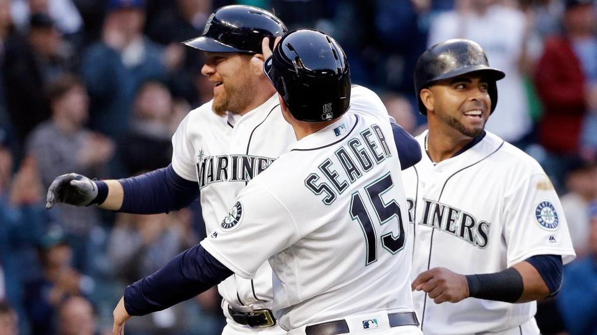 Seattle’s Kyle Seager (15) and Nelson Cruz, right, greet Adam Lind at home on Lind’s three-run home run against the Oakland Athletics on Wednesday, May 25, in Seattle.