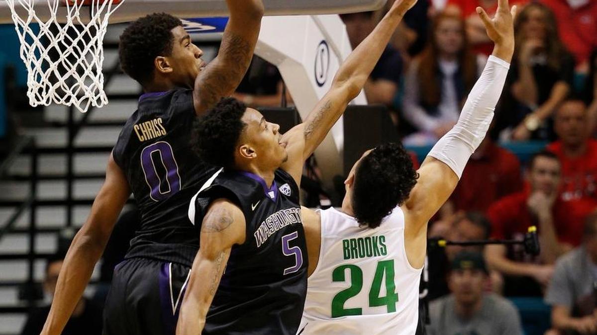 Oregon forward Dillon Brooks, right, shoots against Washington guard Dejounte Murray (5) and Washington forward Marquese Chriss (0) during the first half of an NCAA college basketball game in the quarterfinal round of the Pac-12 men's tournament Thursday, March 10, 2016, in Las Vegas.