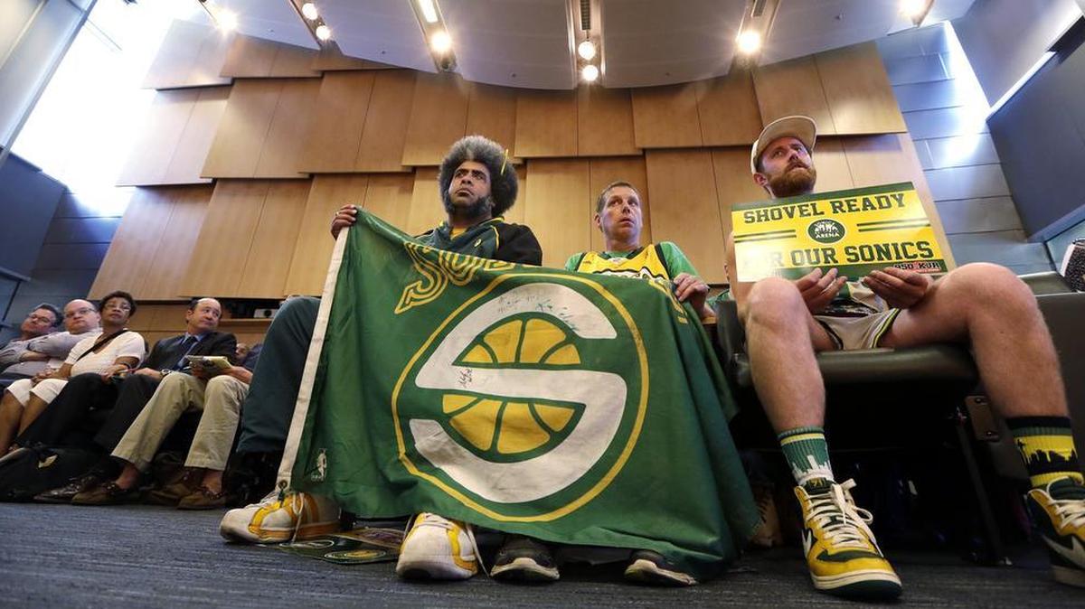 Fans of the defunct Seattle SuperSonics team, from right, Andrew Wergeland-Rammage, Kenneth Knutson and Kris “Sonics Guy” Brannon look on during testimony before the Seattle City Council Monday, May 2. The council vote down a proposal to vacate a stretch of road where an investor hopes to eventually build an arena that could house an NBA and NHL team.