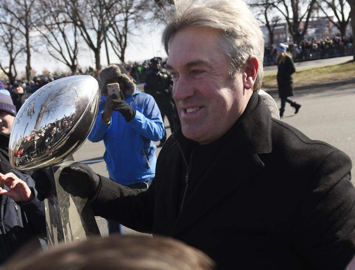 Philadelphia Eagles coach Doug Pederson walks along the parade route with the Lombardi Trophy during the Super Bowl LII victory parade, Thursday, Feb 8, 2018, in Philadelphia.