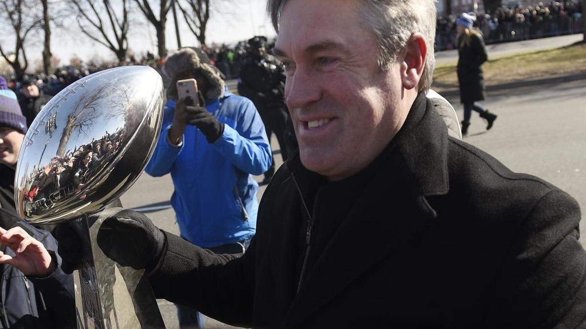 Philadelphia Eagles coach Doug Pederson walks along the parade route with the Lombardi Trophy during the Super Bowl LII victory parade, Thursday, Feb 8, 2018, in Philadelphia.