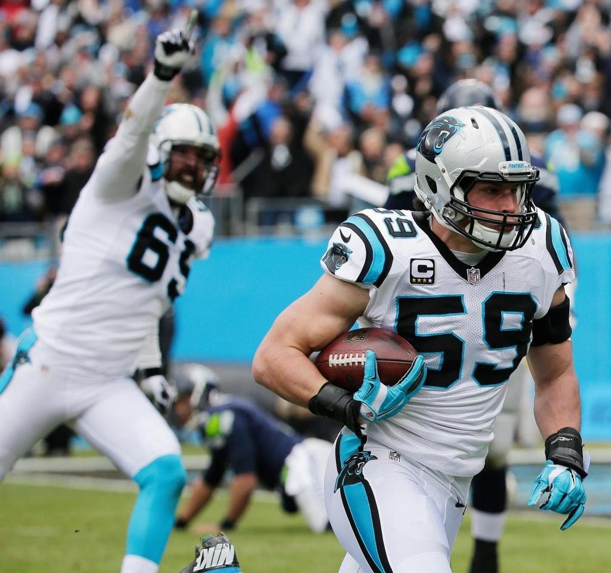 Carolina Panthers middle linebacker Luke Kuechly (59) runs an intercepted ball as Seattle Seahawks center Patrick Lewis (65) looks on during the first half of an NFL divisional playoff football game, Sunday, Jan. 17, 2016, in Charlotte, N.C. Kuechly scored a touchdown on the play.