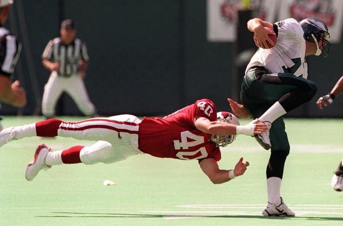 Philadelphia Eagles’ quarterback Doug Pederson, right, scrambles away from Arizona’s Pat Tillman during a game in 1999.