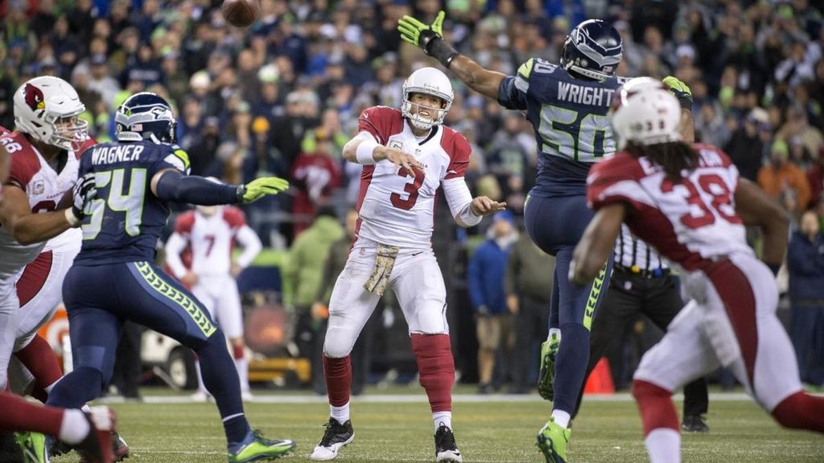 Cardinals quarterback Carson Palmer fires a pass under pressure from Seahawks linebackers Bobby Wagner and K.J. Wright during Sunday night's NFL football game at CenturyLink Field in Seattle on Nov. 15, 2015.
