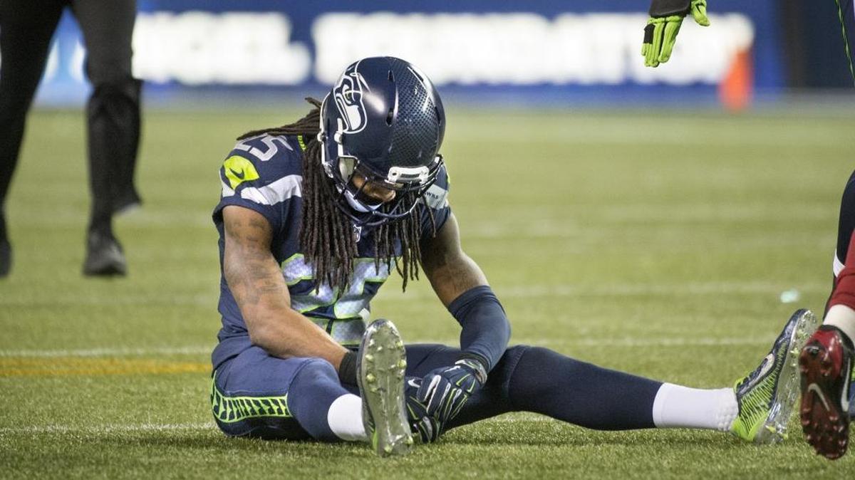 Seahawks corner back Richard Sherman sits on the turf after losing the battle for the ball against Arizona wide receiver Jaron Brown during Sunday night's NFL football game at CenturyLink Field in Seattle on Nov. 15, 2015.
