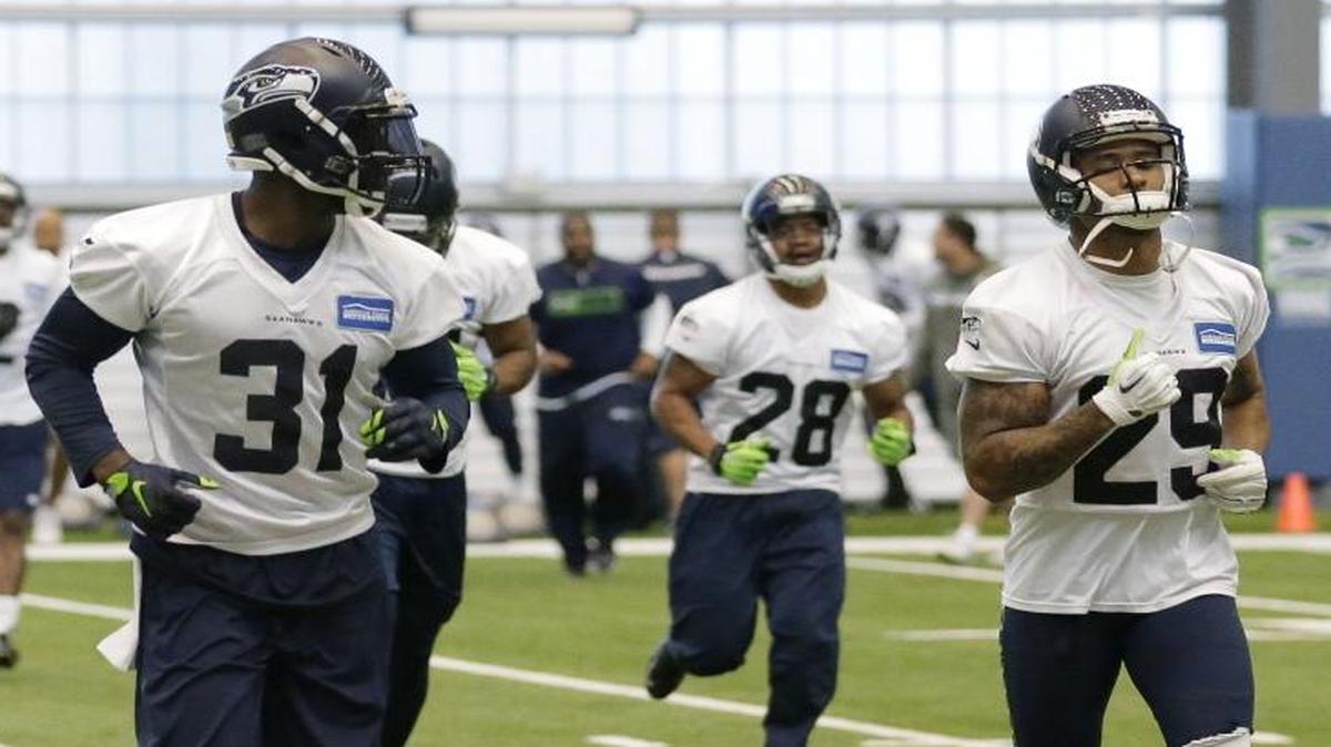 
Seattle Seahawks safety Earl Thomas, right, jogs on the field with Seahawks strong safety Kam Chancellor (31) after an organized team activity in June. Chancellor’s holdout for more money from the Seahawks reached its 25th day Monday. 
