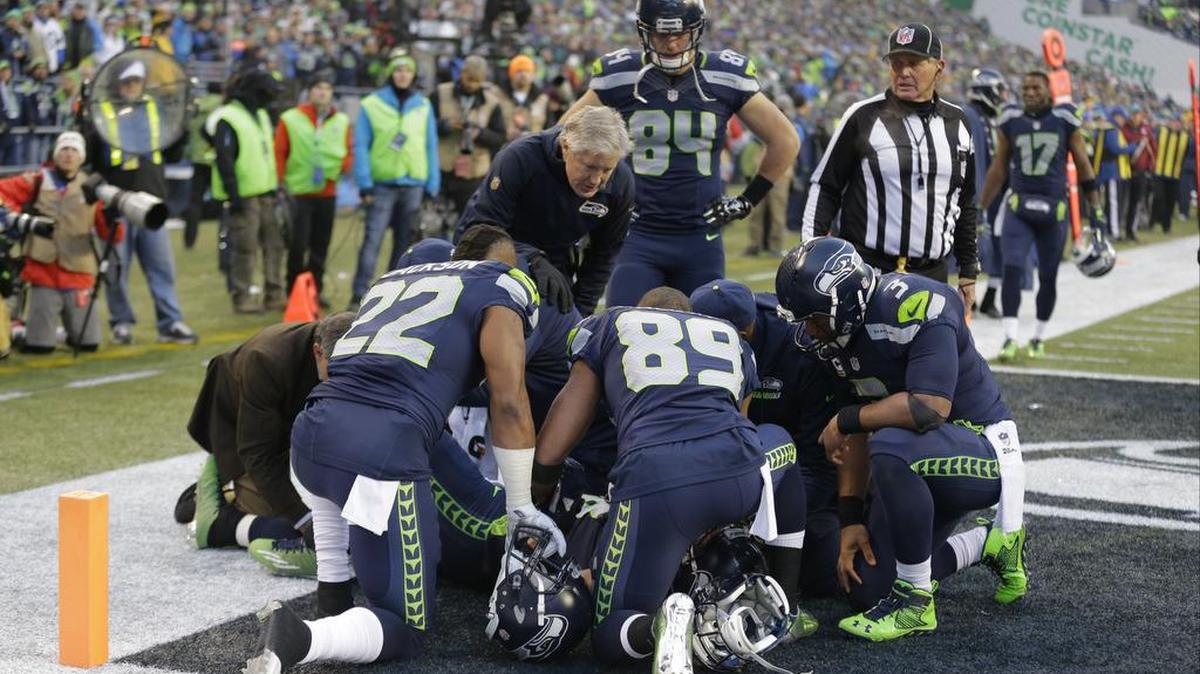 Players and coaches huddle around as Seattle Seahawks’ Jimmy Graham lies on the field after being injured against the Pittsburgh Steelers in the second half of an NFL football game, Sunday, Nov. 29, 2015, in Seattle.