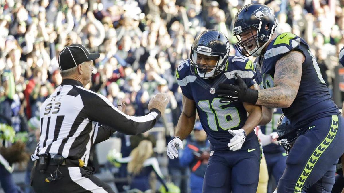 Seattle Seahawks wide receiver Tyler Lockett (16) and offensive guard Justin Britt, right, celebrate in front of back judge Scott Helverson, left, after Lockett scored a touchdown against the San Francisco 49ers in an NFL football game Sunday, Nov. 22, 2015, in Seattle.