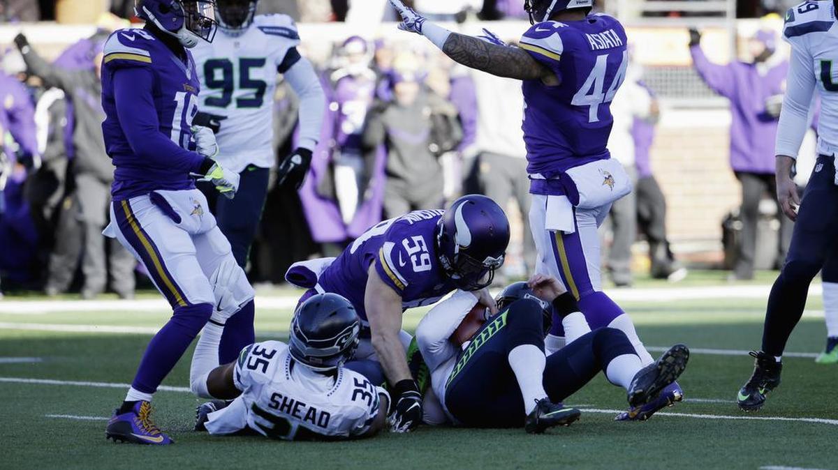 Seattle Seahawks punter Jon Ryan (9) lands after jumping over Minnesota Vikings linebacker Casey Matthews (59) as he runs the ball during the first half of an NFL wild-card football game against the Minnesota Vikings, on Sunday, Jan. 10, 2016, in Minneapolis.