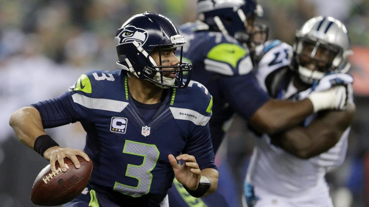 Seattle Seahawks quarterback Russell Wilson (3) scrambles against the Carolina Panthers during the first half of an NFL divisional playoff football game in Seattle, Saturday, Jan. 10, 2015. (AP Photo/John Froschauer)
