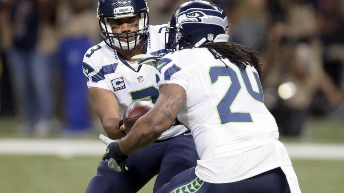 
Seattle Seahawks quarterback Russell Wilson, left, hands off to running back Marshawn Lynch during the first quarter of an NFL football game Sunday, Sept. 13, 2015, in St. Louis.
