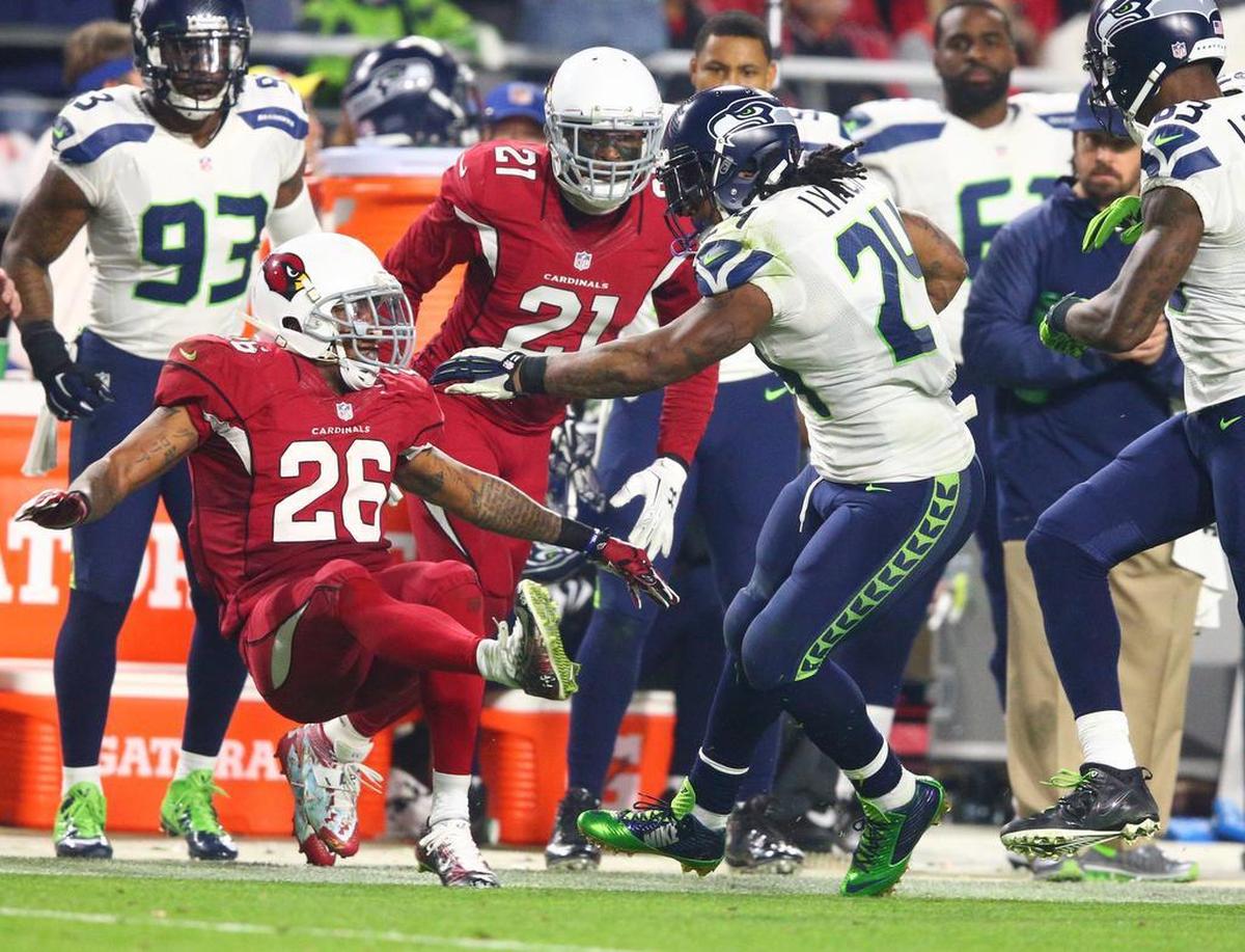 Seahawks running back Marshawn Lynch shakes off Arizona Cardinals safety Rashad Johnson and Cardinals cornerback Patrick Peterson on his way to a 79-yard touchdown during the fourth quarter on Dec. 21, 2014.