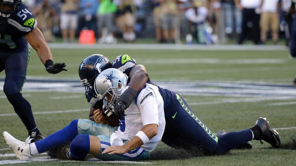 Cliff Avril of the Seahawks, sacking Tony Romo, in white, has been taking some heat from Dallas fans for hurting the Cowboys’ quarterback on this play Thursday, Aug. 25, 2016, in Seattle.