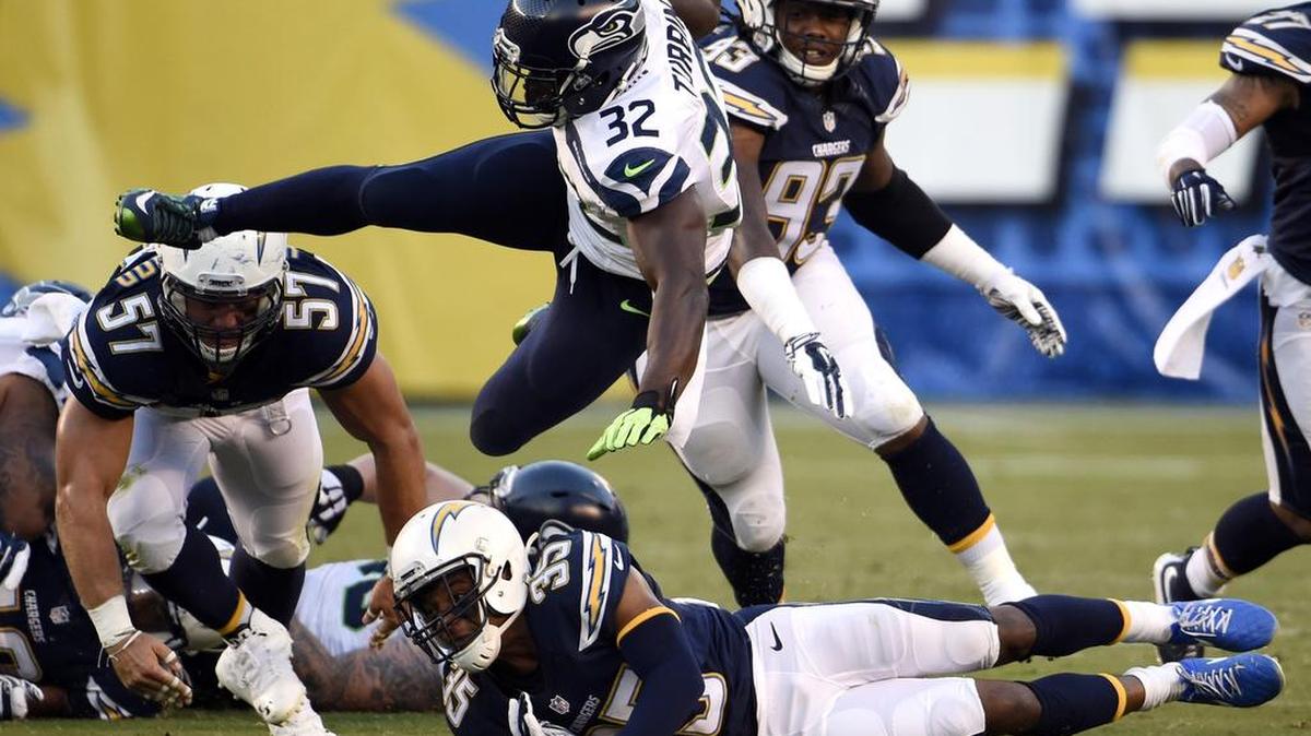 
Seattle Seahawks running back Robert Turbin (32) leaps over San Diego Chargers cornerback Richard Crawford (35) during the second half of a preseason game on Aug. 29 in San Diego. 
