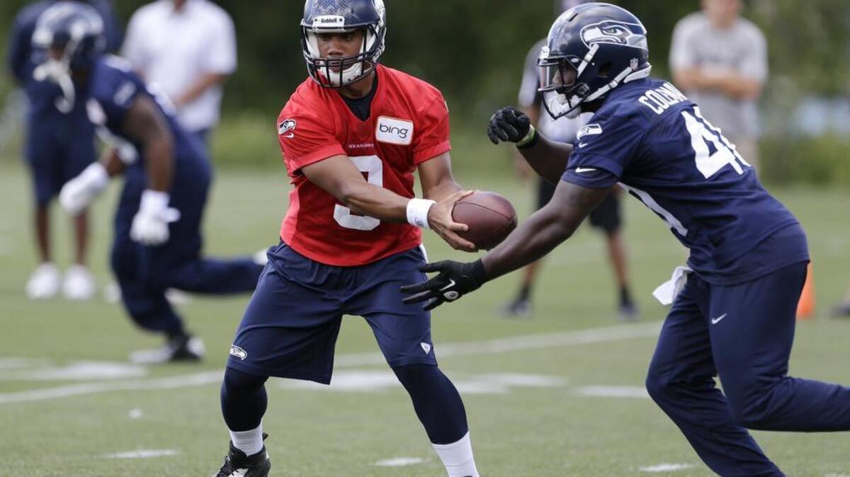 Seahawks fullback Derrick Coleman, right, takes a handoff from quarterback Russell Wilson during a practice. Bellevue police chief Steve Mylett says his department did not purposely drag out the investigation into Coleman’s car crash.