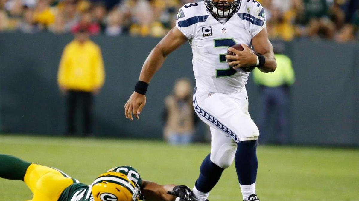 
Seattle Seahawks' Russell Wilson runs past Green Bay Packers' Nick Perry during the second half of an NFL football game Sunday, Sept. 20, 2015, in Green Bay, Wis.
