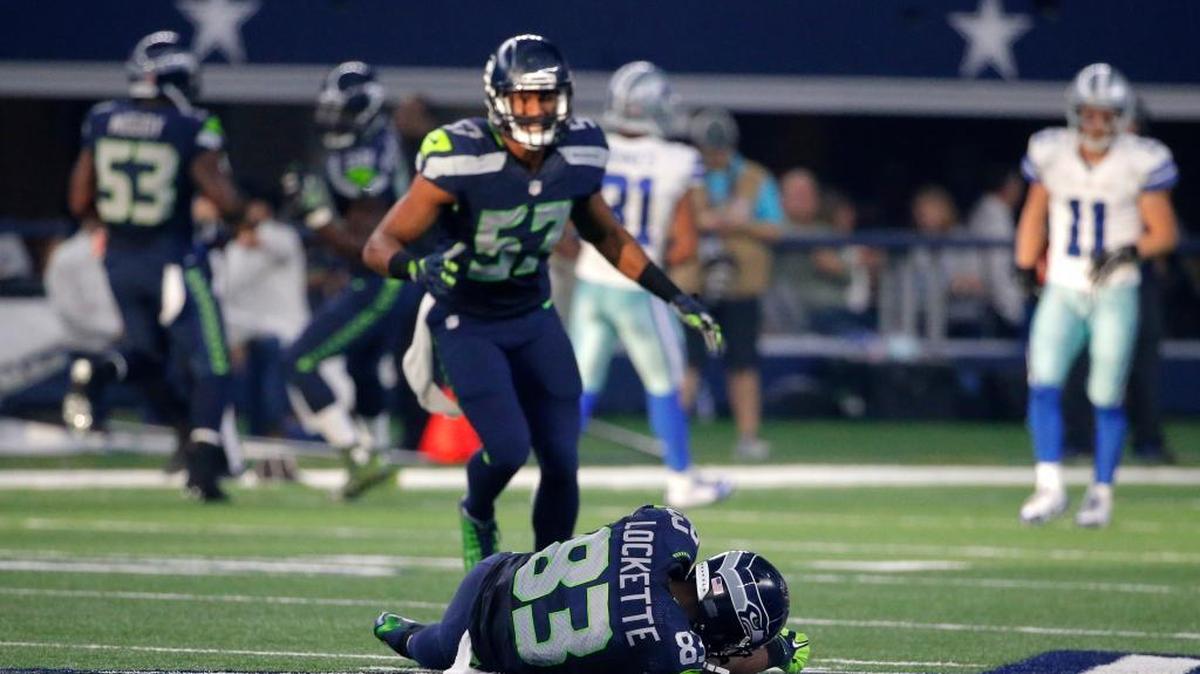 Seattle Seahawks' Mike Morgan (57) looks down at teammate Ricardo Lockette (83), who lays on the ground after suffering a neck injury and concussion following a hit during a punt return Sunday.
