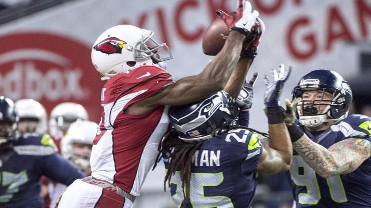 Cardinals wide receiver Jaron Brown pulls in a juggling catch over Seahawks cornerback Richard Sherman and defensive end Cassius Marsh (91) during Sunday night's NFL football game at CenturyLink Field in Seattle on Nov. 15, 2015..