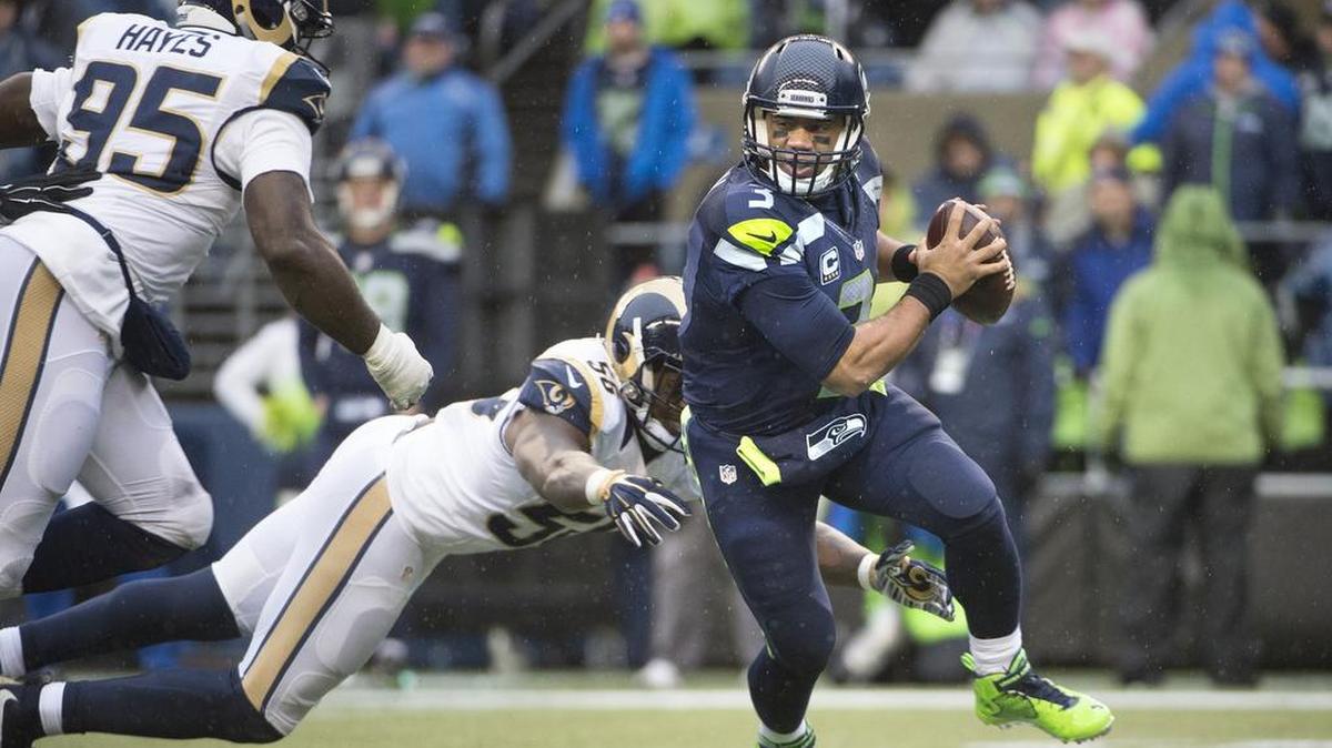 Seahawks quarterback Russell Wilson, right, tries to escape the pressure from Rams linebacker Akeem Ayers and defensive end William Hayes (95) in a game versus the St. Louis Rams on Dec. 27.