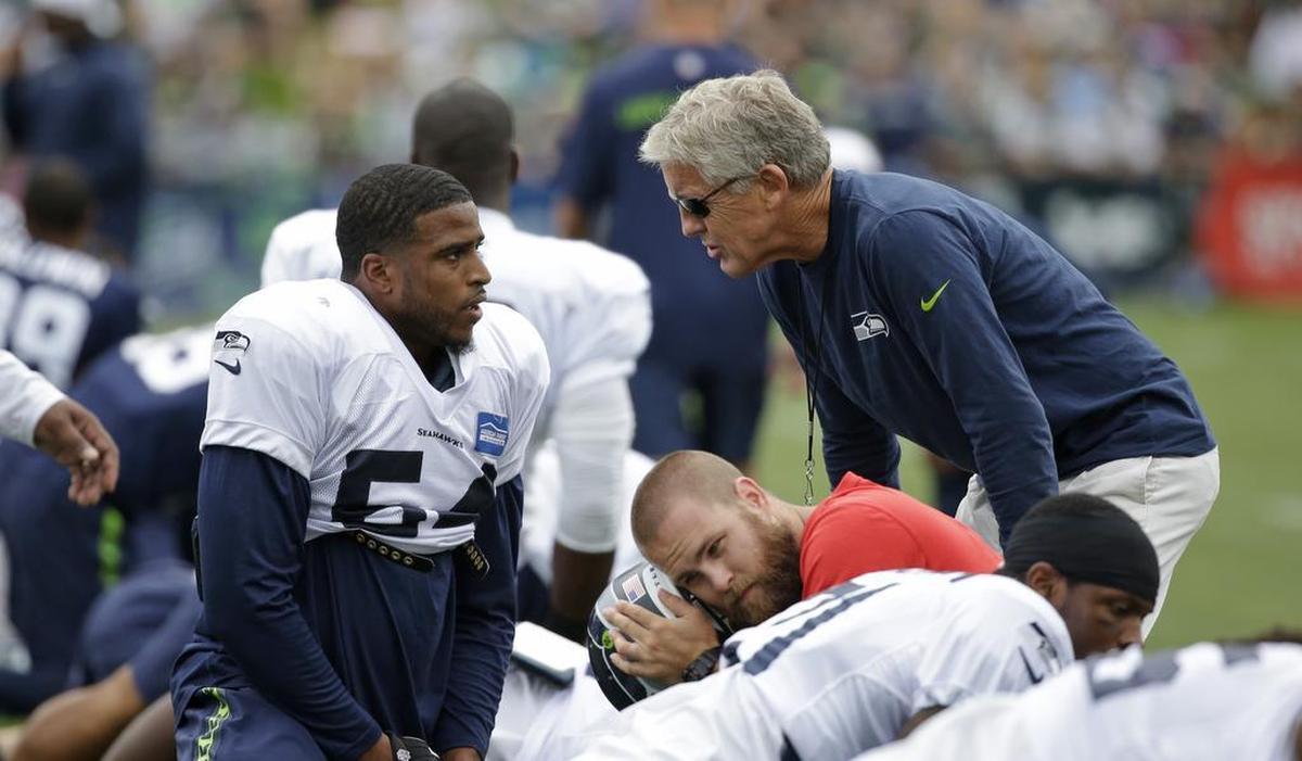 Seattle Seahawks head coach Pete Carroll, right, talks with Bobby Wagner at an NFL football training camp Monday, Aug. 3, 2015, in Renton, Wash.