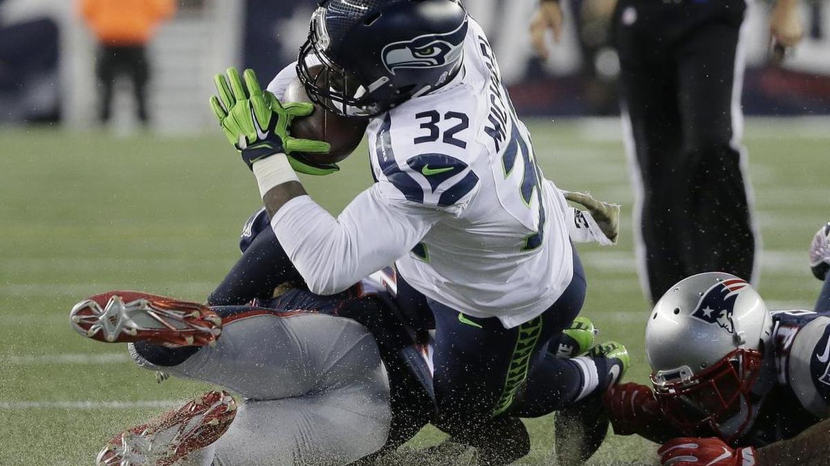 New England defenders tackle Seattle running back Christine Michael (32) Sunday. Michael was waived by the Seahawks on Tuesday.