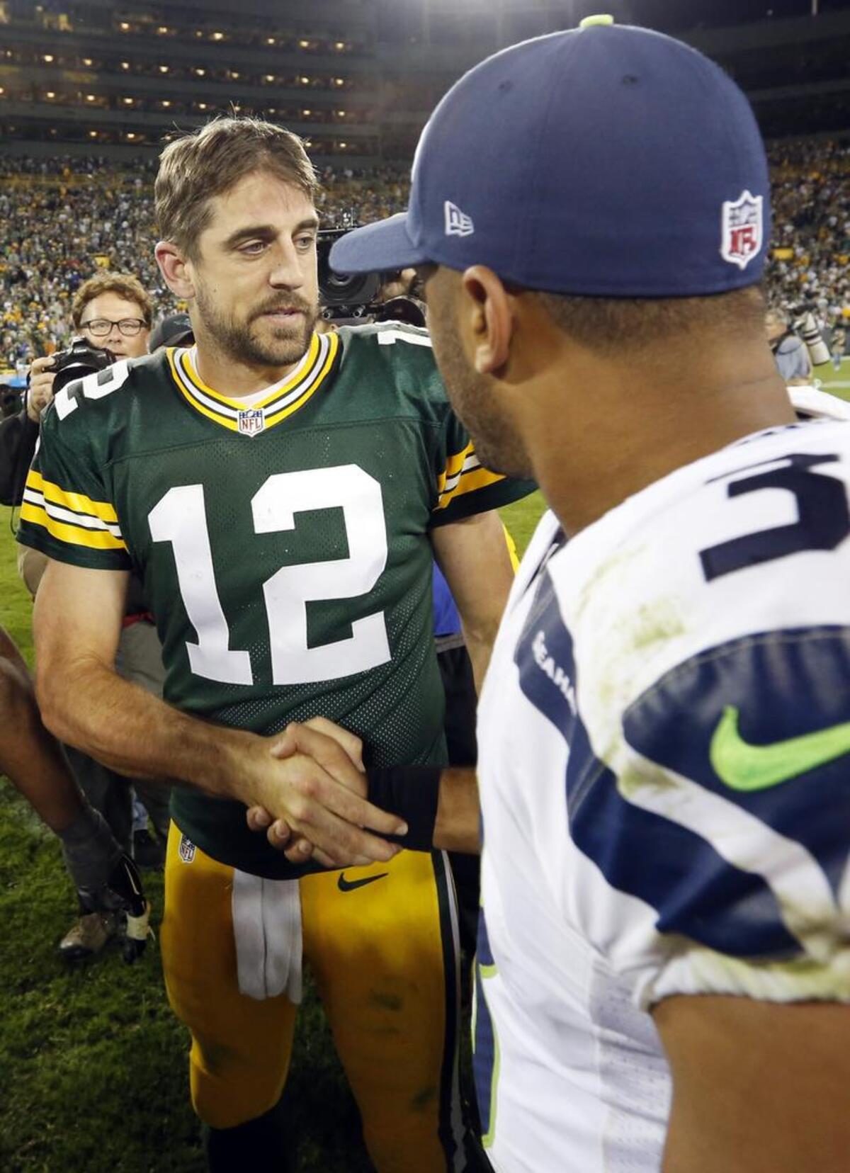 Green Bay Packers’ Aaron Rodgers shakes hands with Seattle Seahawks’ Russell Wilson during the second half of an NFL football game Sunday, Sept. 20, 2015, in Green Bay, Wis. The Packers won 27-17.