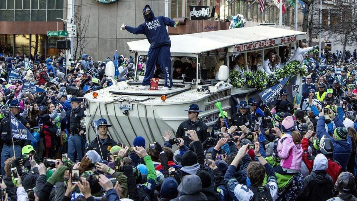 Seattle’s Marshawn Lynch throws skittles to the crowd during the Super Bowl parade in Seattle on Feb. 5, 2014.