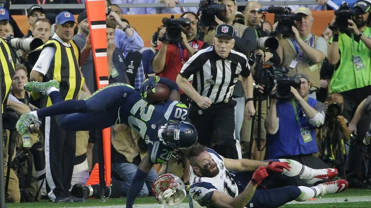 Seattle Seahawks cornerback Jeremy Lane (20) is tackled by New England Patriots wide receiver Julian Edelman (11) after intercepting New England Patriots quarterback Tom Brady during the first half of NFL Super Bowl XLIX football game Sunday, Feb. 1, 2015, in Glendale, Ariz.