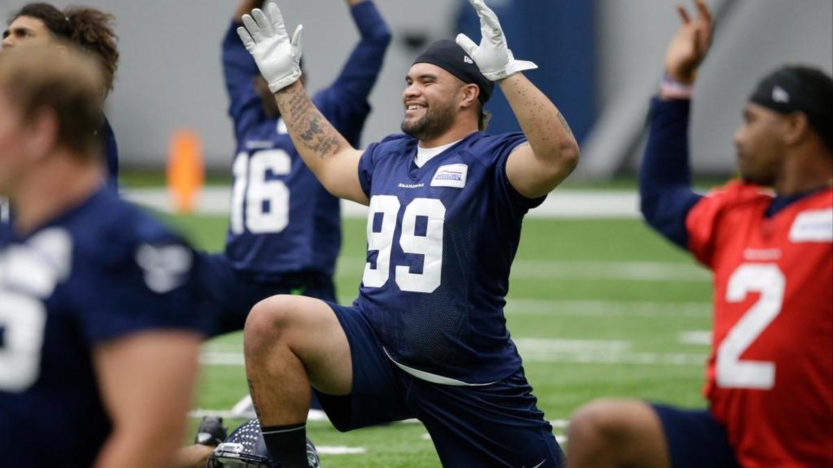 Seattle’s new fullback Taniela Tupou (99) stretches during a rookie minicamp workout this past Sunday. Tupou graduated from Archbishop Murphy High School and played on the defensive line for the University of Washington.