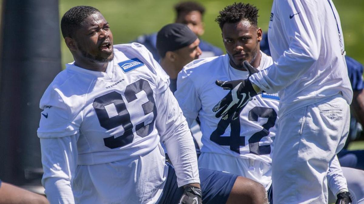 Coach Pete Carroll talks during Seahawks minicamp this month with rookie defensive tackle Jaran Reed at the Virginia Mason Athletic Center in Renton. That’s where the team is having the first of nine organized team activity days on the field this week.