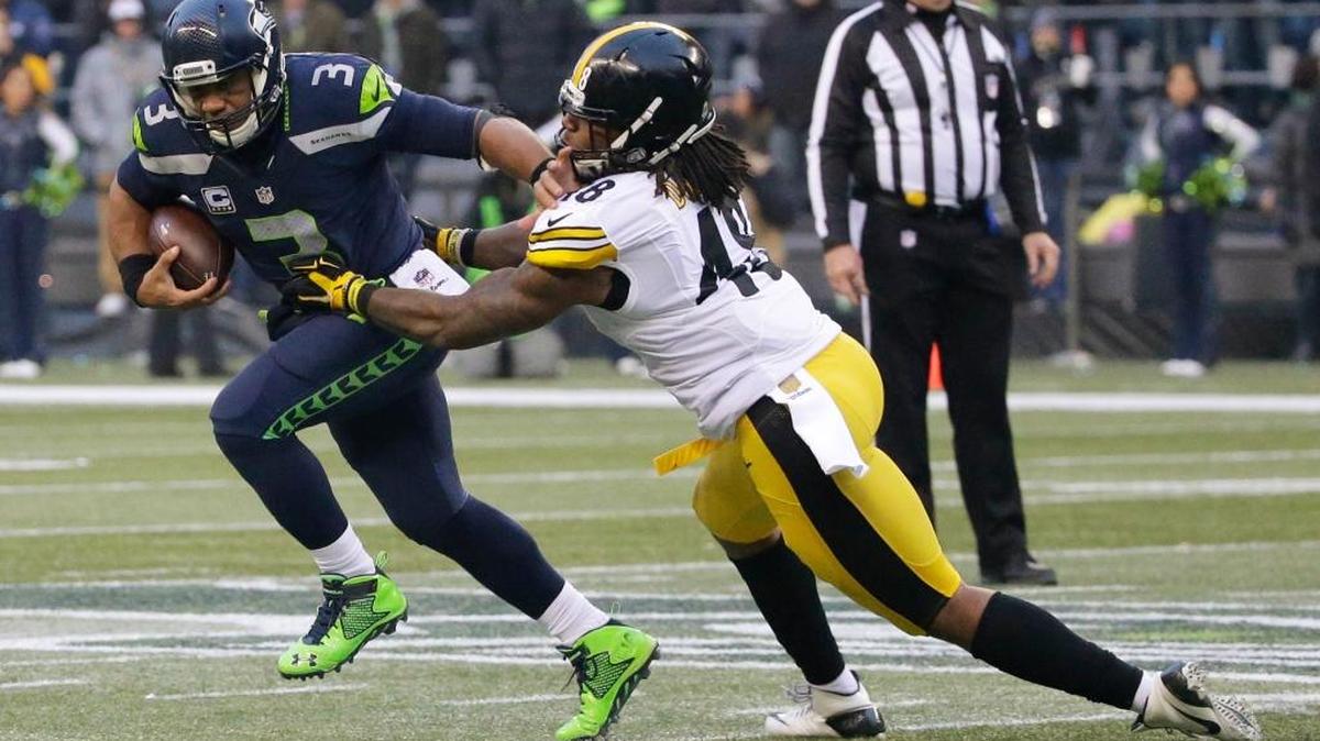 Seattle Seahawks quarterback Russell Wilson pushes Pittsburgh Steelers linebacker Bud Dupree, right, away as he scrambles with the ball in the second half of an NFL football game, Sunday, Nov. 29, in Seattle.