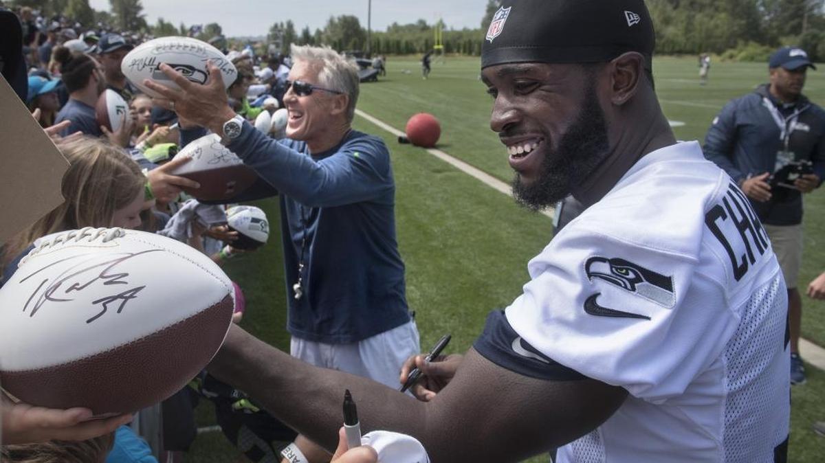 Seattle Seahawks head coach Pete Carroll and safety Kam Chancellor sign autographs for fans following the practice on the opening day of training camp in 2016 at the team's Virginia Mason Athletic Complex in Renton.