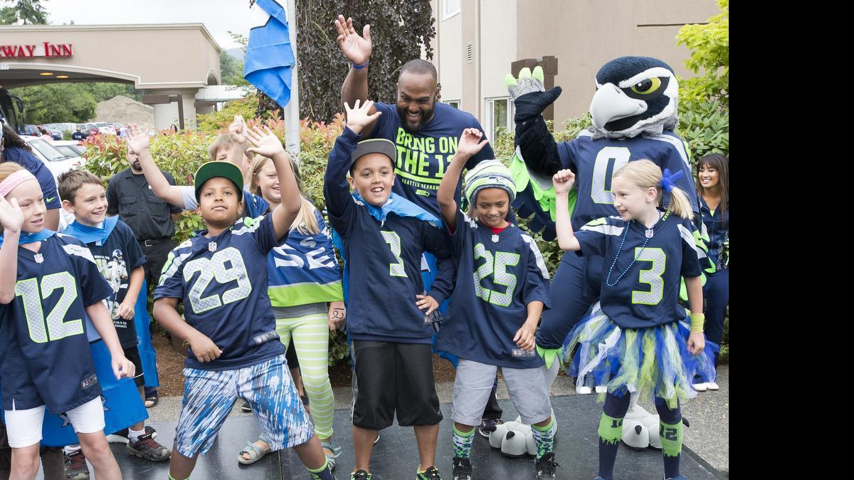 Children perform dance moves “the Whip” and “the Nae Nae” with Seattle Seahawks defensive lineman Julius Warmsley during the Seahawks 12-Tour in 2015.