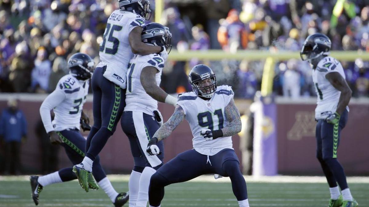 Seattle Seahawks defensive end Cassius Marsh (91) and defensive players react to a play during the second half of an NFL wild-card football game against the Minnesota Vikingson Sunday, Jan. 10, 2016, in Minneapolis.