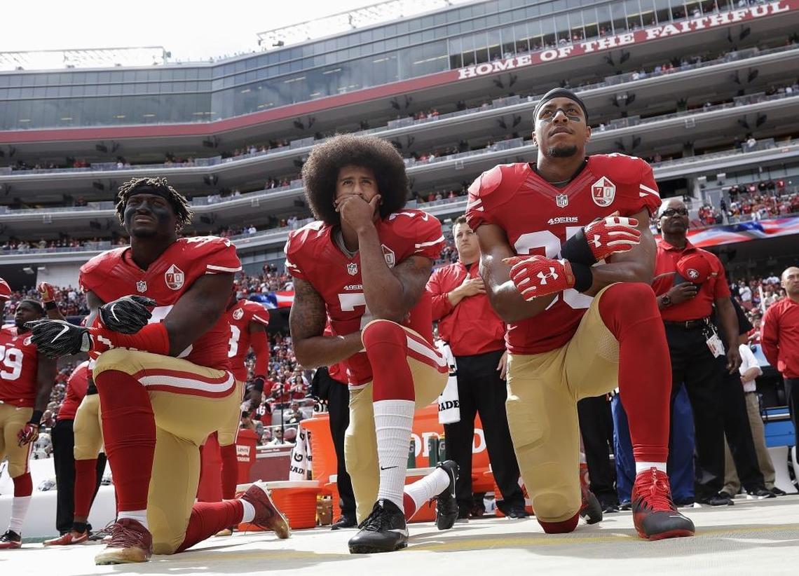 Safety Eric Reid, right, kneels with then-San Francisco 49ers quarterback Colin Kaepernick, center, and outside linebacker Eli Harold, left, during the national anthem before the team’s home game against the Dallas Cowboys in October 2016. Friday, the league and lawyers for Kaepernick and Reid announced a settlement in the players’ collusion case against the NFL.