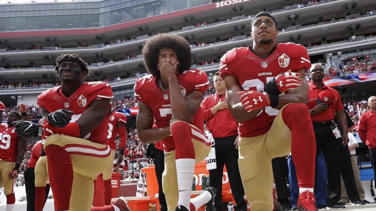 Safety Eric Reid, right, kneels with then-San Francisco 49ers quarterback Colin Kaepernick, center, and outside linebacker Eli Harold, left, during the national anthem before the team’s home game against the Dallas Cowboys in October 2016. Friday, the league and lawyers for Kaepernick and Reid announced a settlement in the players’ collusion case against the NFL.