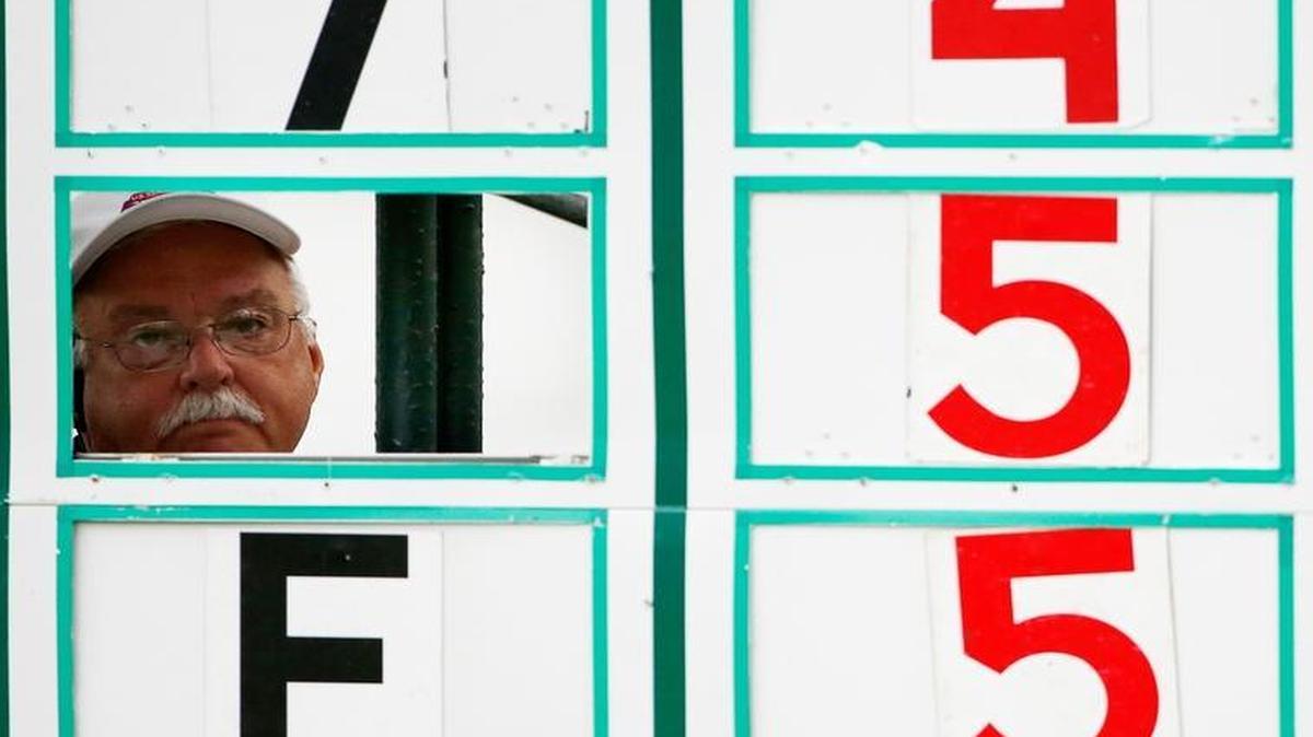 An official looks out while changing numbers on the leader board during the first round of the U.S. Senior Open golf tournament Thursday in Peabody, Mass.