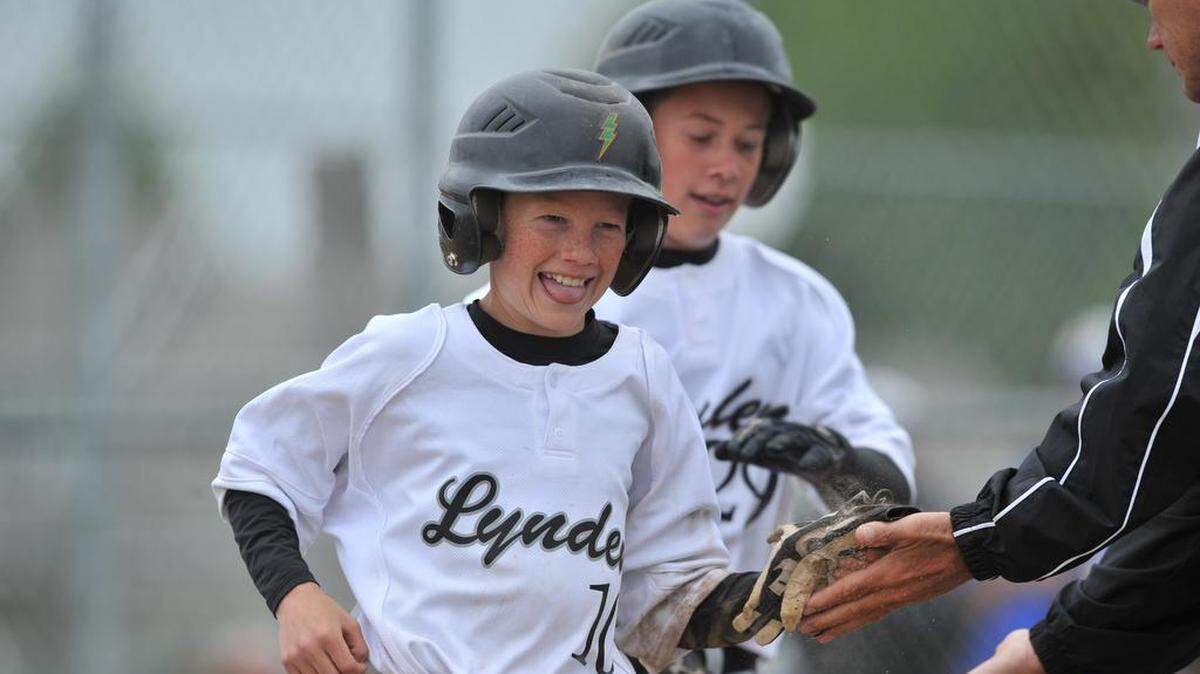Lynden's Marc Meenderinck, left, gets congratulations after scoring a run during the 38th Annual Hub DeJong youth baseball tournament June 26, 2010 in Lynden. DeJong, a longtime supporter of youth sports, died Saturday, Sept. 26, 2015.