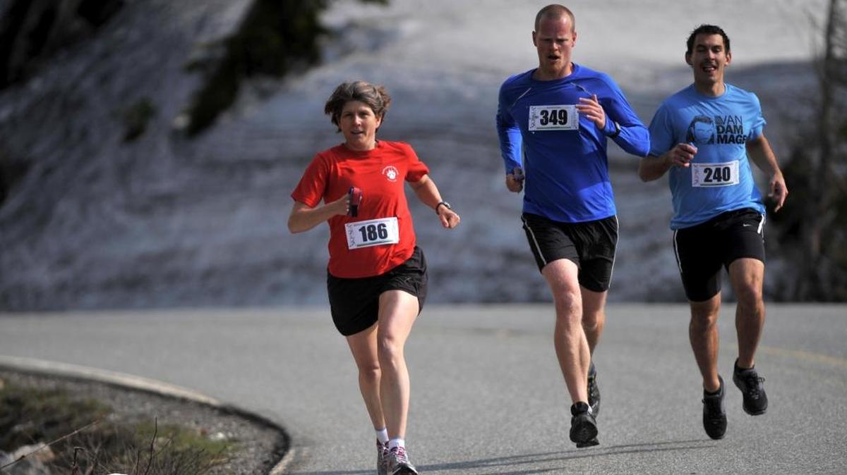 Aven Construction runner Christy Fazio, left, Still Looking For A Sponsor's Trevor Davison and VanDammage's Anders Mavis run down the Mount Baker High way during the 2011 Ski to Sea Race.